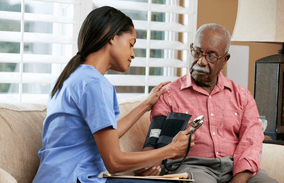 Professional healthcare worker with an older Nigerian adult in a home setting